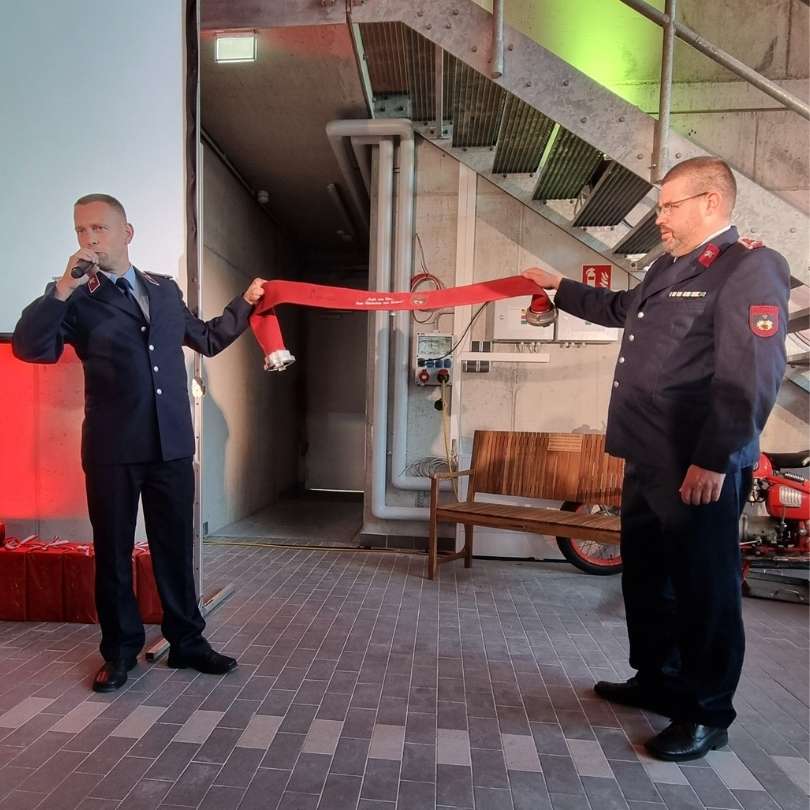 Feuerwehrleute aus Großenhain überreichen Feuerwehrschlauch